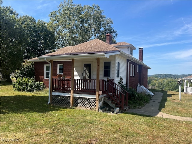 view of front of property featuring covered porch and a front yard