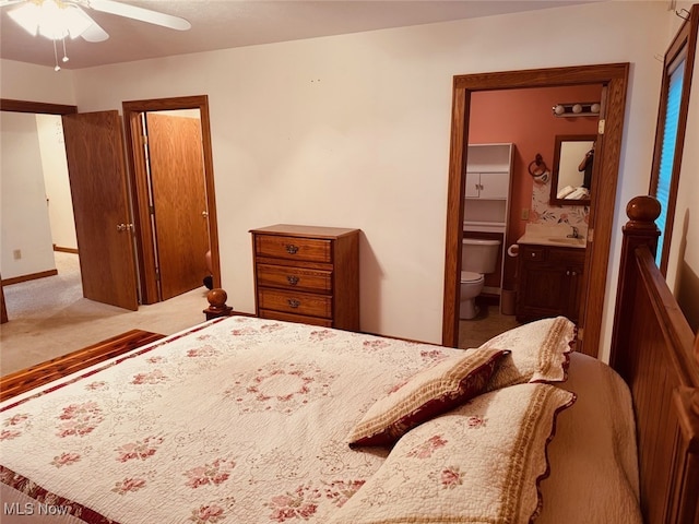 bedroom featuring carpet flooring, ensuite bath, ceiling fan, and sink