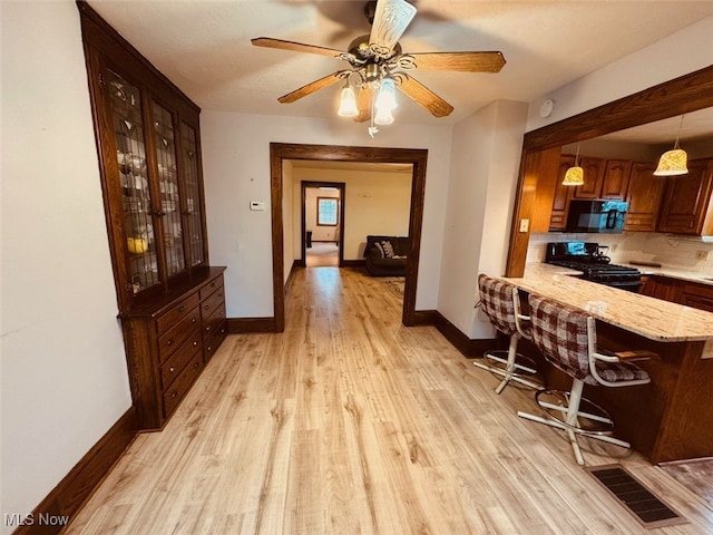 dining room featuring ceiling fan, light hardwood / wood-style flooring, and a textured ceiling