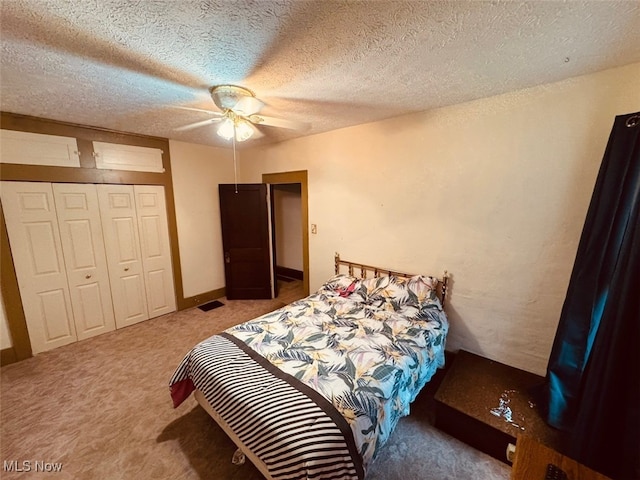 carpeted bedroom featuring ceiling fan, a closet, and a textured ceiling