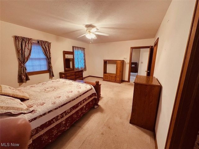 carpeted bedroom featuring ceiling fan and a textured ceiling