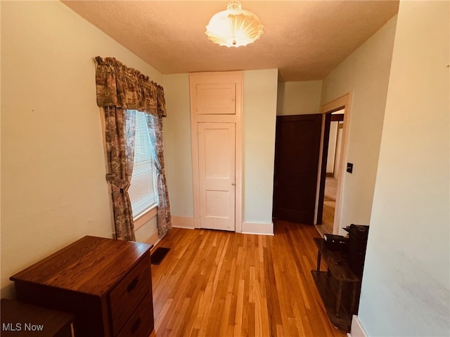 hallway featuring a textured ceiling and light hardwood / wood-style floors