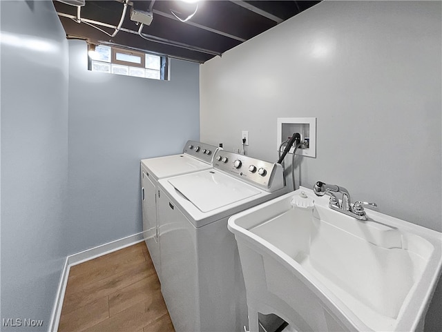 washroom with washer and clothes dryer, hardwood / wood-style floors, and sink