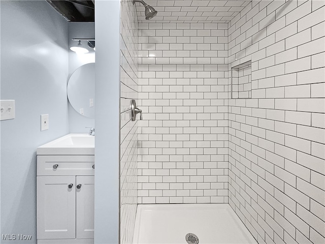 bathroom with vanity and tiled shower