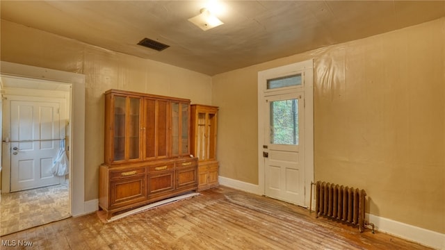 bedroom with light hardwood / wood-style floors and radiator