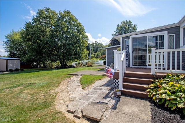 view of yard featuring a patio, a deck, and a shed