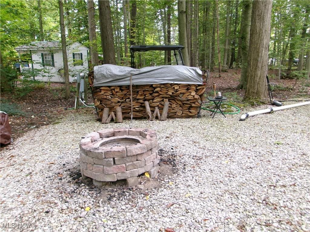 view of yard with a fire pit and an outdoor structure