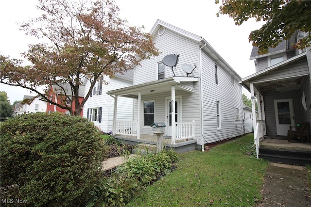 back of property featuring a yard and a porch