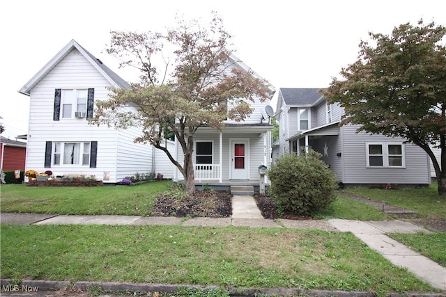 front facade featuring covered porch and a front yard