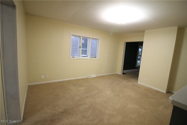 unfurnished room featuring light colored carpet