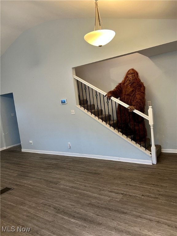 stairway with vaulted ceiling and hardwood / wood-style flooring