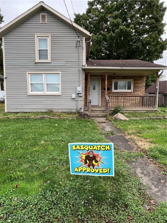 view of front of property with a porch and a front lawn