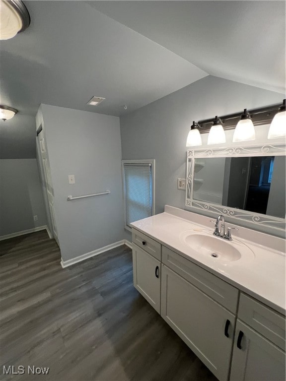 bathroom featuring lofted ceiling, vanity, and hardwood / wood-style floors