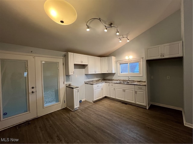 kitchen with vaulted ceiling, dark hardwood / wood-style floors, sink, and white cabinets