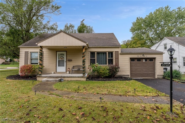 view of front of home with a front lawn, covered porch, and a garage