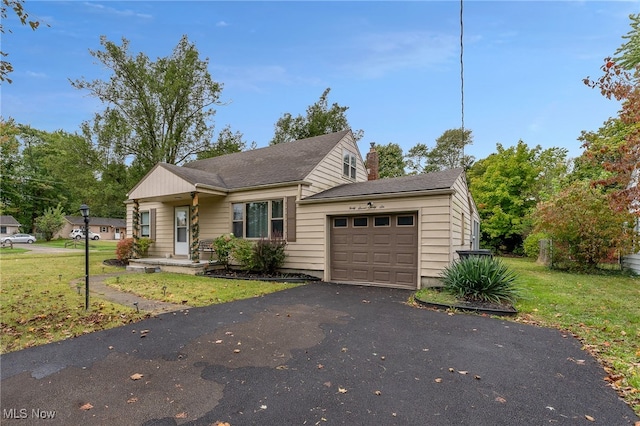 view of front of house featuring a garage and a front lawn