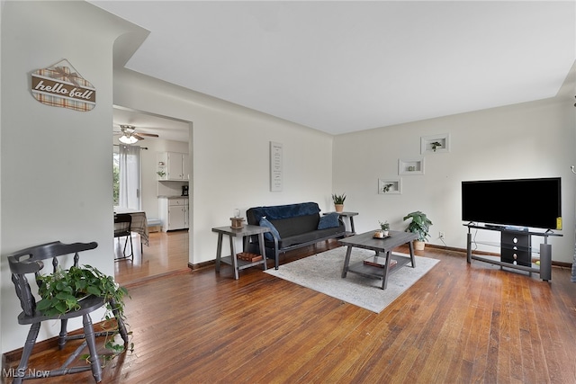 living room with dark wood-type flooring and ceiling fan