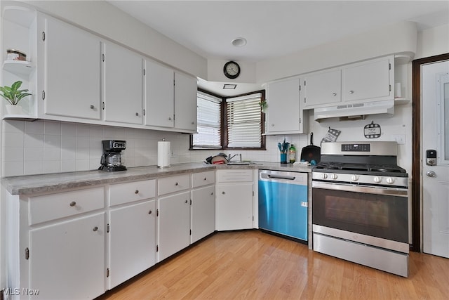 kitchen with light hardwood / wood-style floors, white cabinetry, custom exhaust hood, and stainless steel appliances