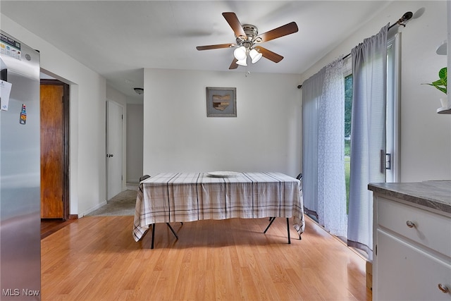 dining space with ceiling fan and light hardwood / wood-style flooring