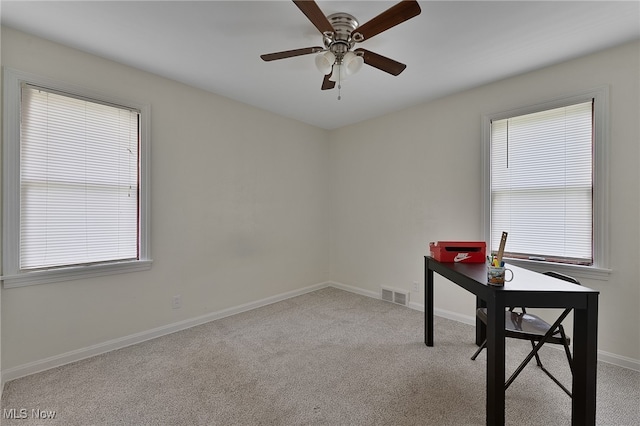 carpeted home office with ceiling fan