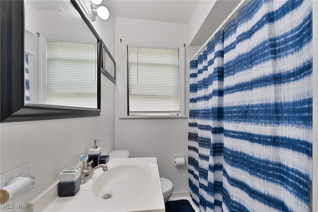 bathroom with sink, toilet, and curtained shower