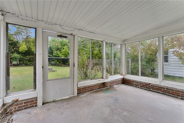 unfurnished sunroom featuring lofted ceiling and a wealth of natural light