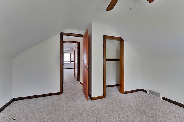 additional living space with lofted ceiling, light carpet, and ceiling fan