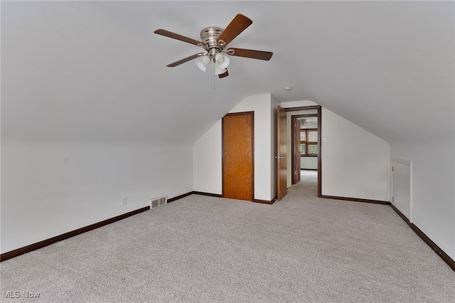 bonus room featuring lofted ceiling, light carpet, and ceiling fan