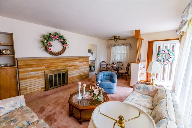 living room featuring carpet flooring, ceiling fan, and a fireplace