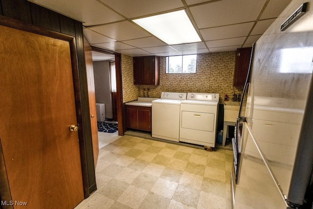 clothes washing area with cabinets and separate washer and dryer