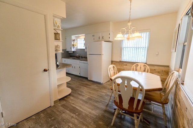 dining space featuring an inviting chandelier, dark wood-type flooring, and sink