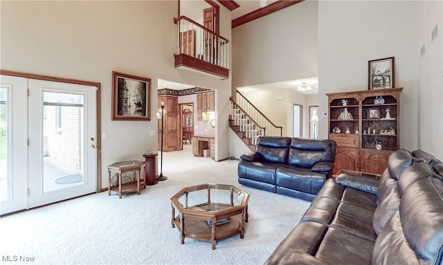 carpeted living room featuring crown molding and a high ceiling