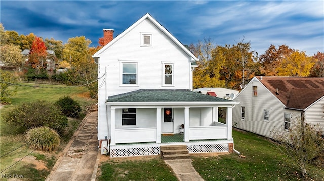 view of front of home with a porch and a front lawn