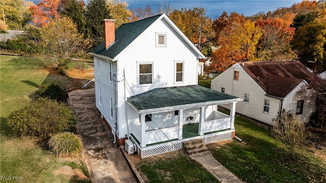 back of house featuring a porch and a lawn