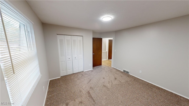 unfurnished bedroom with a closet and carpet