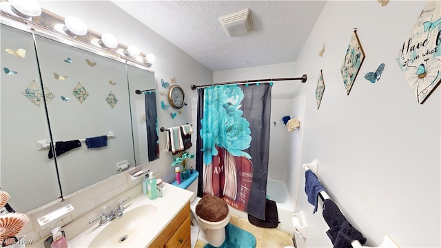 full bathroom with shower / bath combo with shower curtain, a textured ceiling, vanity, and toilet