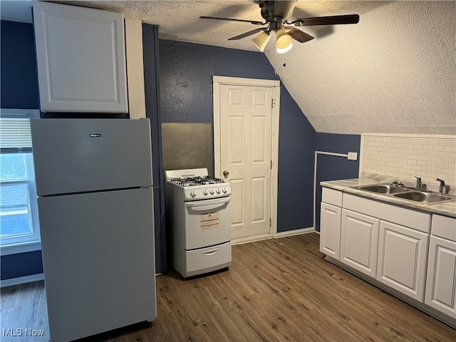 kitchen featuring white cabinetry, white appliances, dark hardwood / wood-style flooring, ceiling fan, and sink