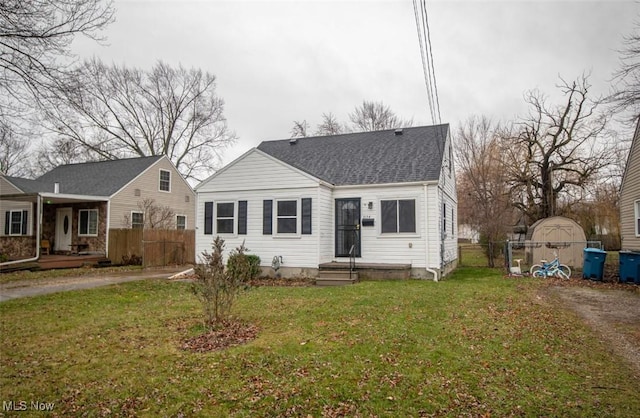 view of front of property featuring a storage shed and a front yard