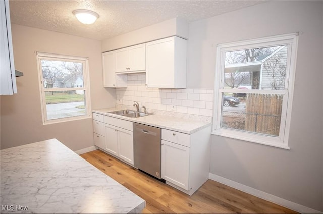 kitchen featuring white cabinetry, dishwasher, sink, decorative backsplash, and light wood-type flooring