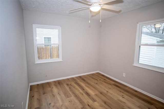 spare room with ceiling fan, a textured ceiling, and light hardwood / wood-style floors