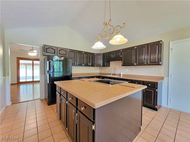 kitchen featuring vaulted ceiling, black refrigerator, a center island, and ceiling fan