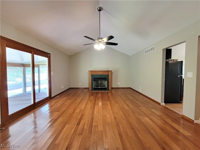 unfurnished living room with light hardwood / wood-style flooring, lofted ceiling, ceiling fan, and a fireplace