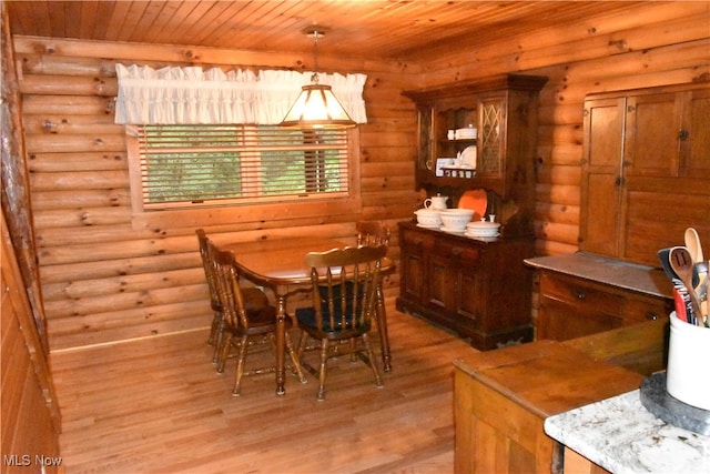 dining space with wood ceiling, light hardwood / wood-style floors, and log walls