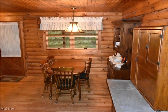 dining room with light wood-type flooring, log walls, and wooden ceiling