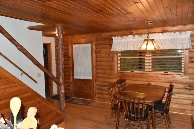 dining area featuring hardwood / wood-style flooring, log walls, and wooden ceiling