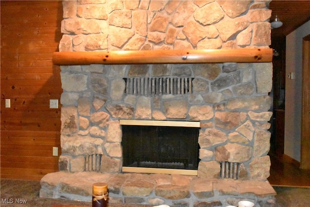 interior details featuring a fireplace and wooden walls