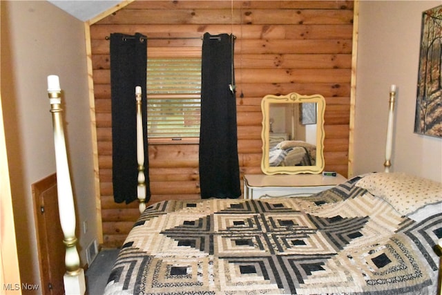 bedroom featuring log walls