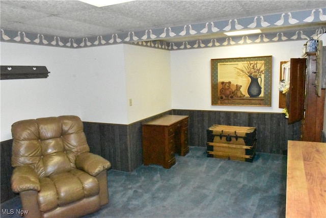 living area with a textured ceiling and carpet floors