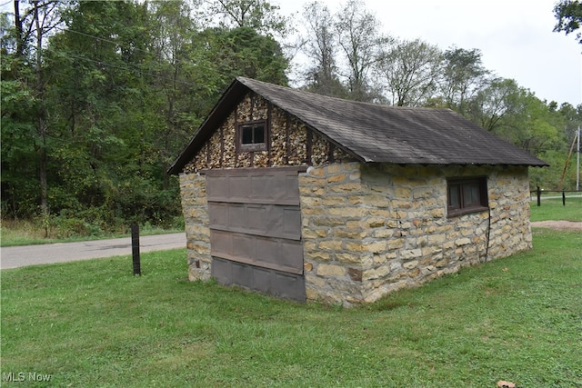 view of outbuilding featuring a lawn