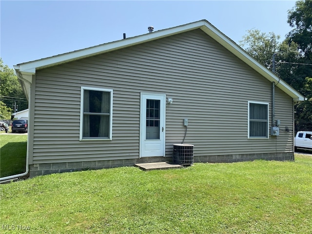 rear view of property featuring a lawn